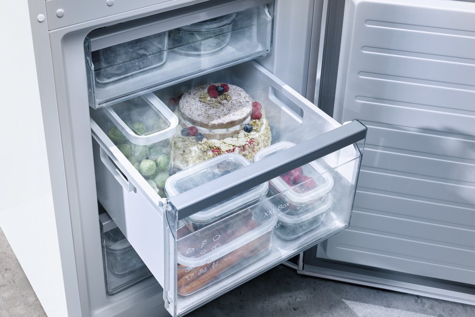 Inside of Miele freezer, with drawer pulled out to show food stored inside.